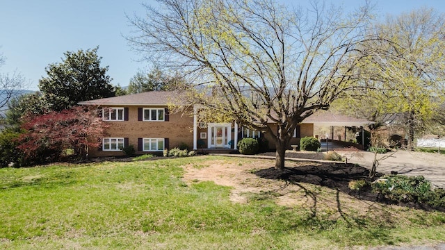 split level home featuring concrete driveway, an attached carport, and a front yard