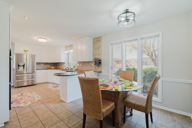 dining room featuring light tile patterned floors and baseboards