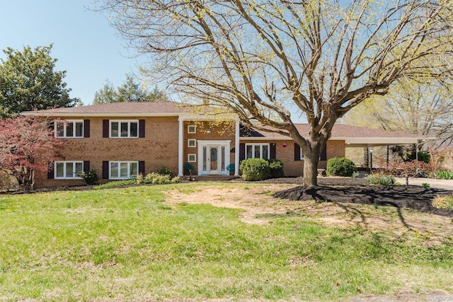split level home with french doors, a front lawn, brick siding, and concrete driveway