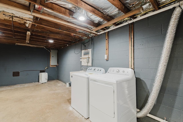 clothes washing area with washing machine and dryer and electric panel