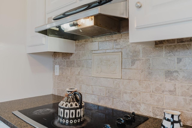 kitchen with under cabinet range hood, white cabinetry, and tasteful backsplash