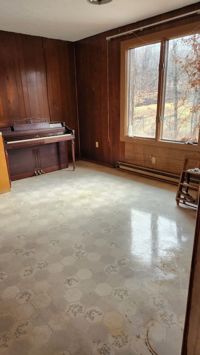 empty room featuring wood walls and baseboard heating