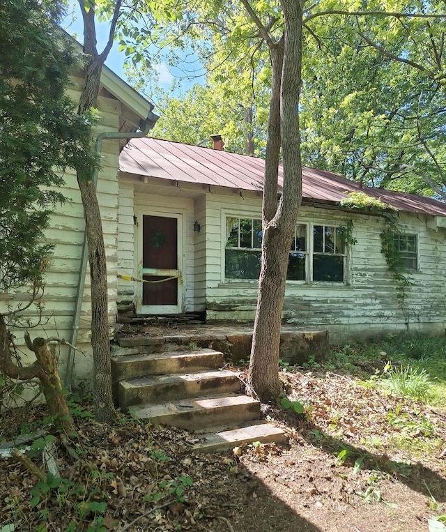 view of front of home with entry steps and metal roof