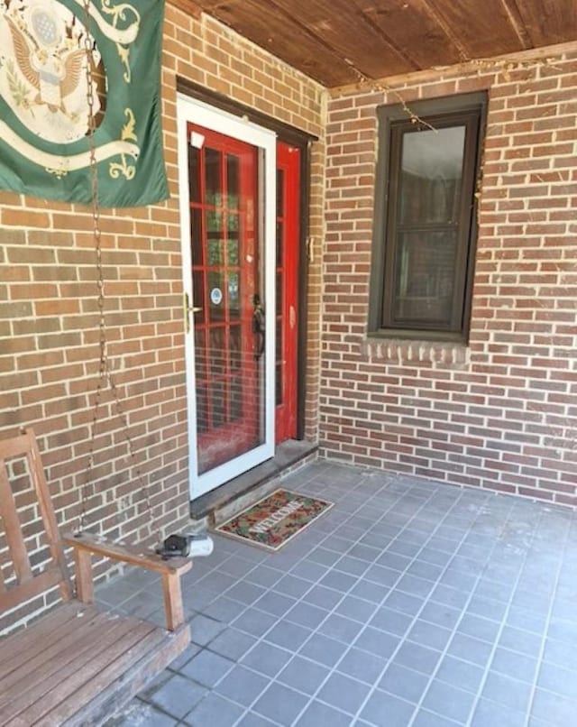 doorway to property featuring brick siding
