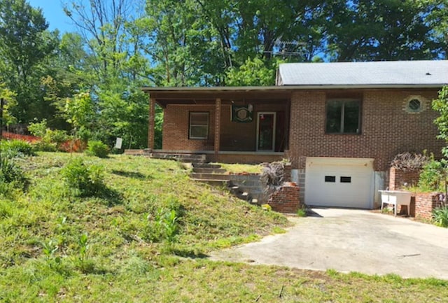 view of front facade featuring driveway, an attached garage, brick siding, and a porch