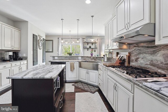 5761 Agecroft Rd, Spotsylvania, VA 22551 - kitchen featuring a sink, under cabinet range hood, stainless steel gas stovetop, a peninsula, and dark wood-style flooring
