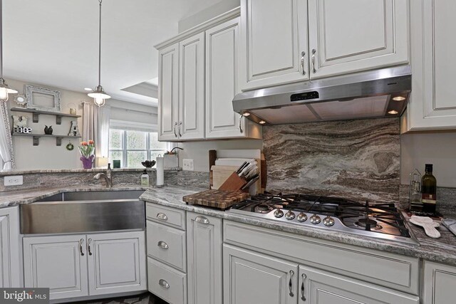 5761 Agecroft Rd, Spotsylvania, VA 22551 - kitchen with under cabinet range hood, stainless steel gas stovetop, a sink, white cabinets, and tasteful backsplash
