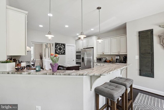 5761 Agecroft Rd, Spotsylvania, VA 22551 - kitchen featuring appliances with stainless steel finishes, recessed lighting, a breakfast bar, baseboards, and hanging light fixtures