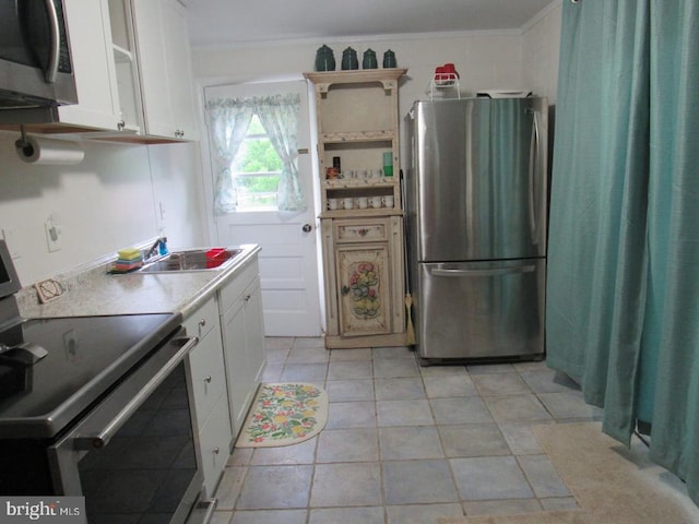 kitchen featuring white cabinetry, appliances with stainless steel finishes, and ornamental molding