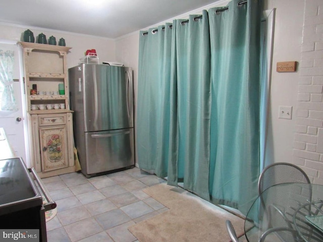 kitchen with crown molding, range with electric stovetop, and stainless steel fridge