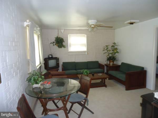 living room with light colored carpet and ceiling fan