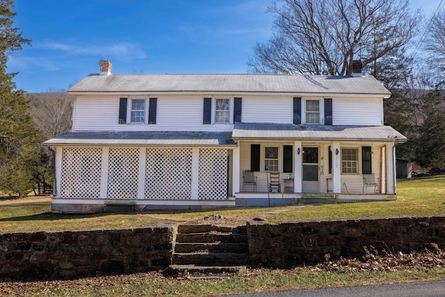 view of front of house featuring a porch, a front yard, and a chimney