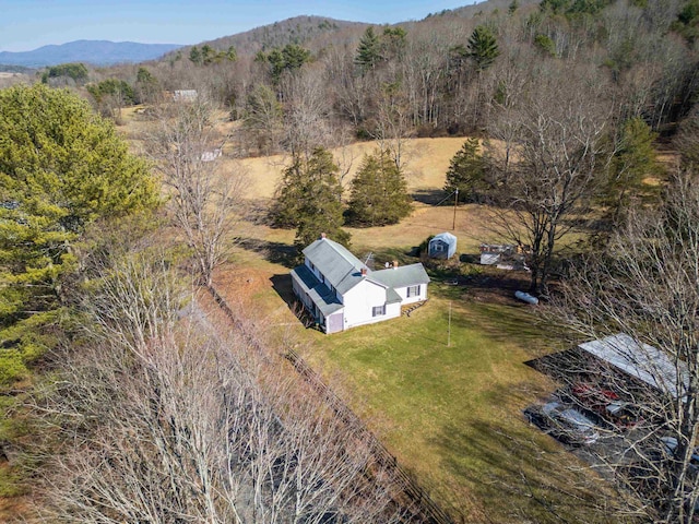 birds eye view of property featuring a rural view, a mountain view, and a view of trees