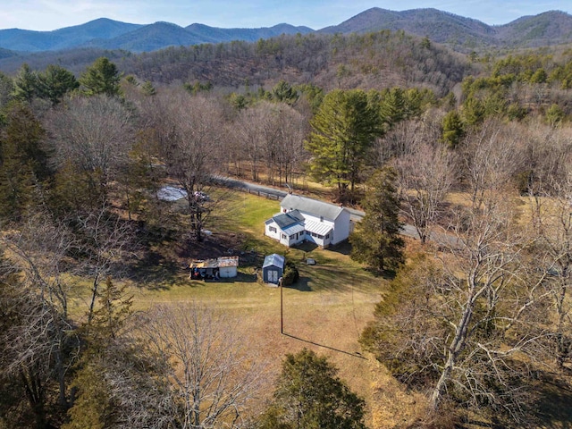 aerial view with a mountain view, a view of trees, and a rural view