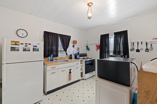 kitchen featuring white appliances, light floors, a sink, light countertops, and white cabinetry