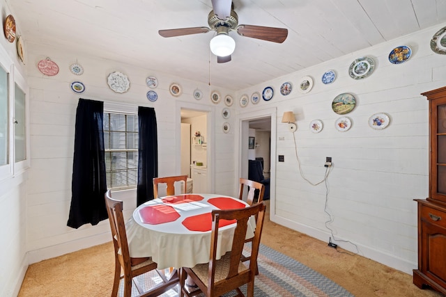 dining space featuring ceiling fan and light carpet