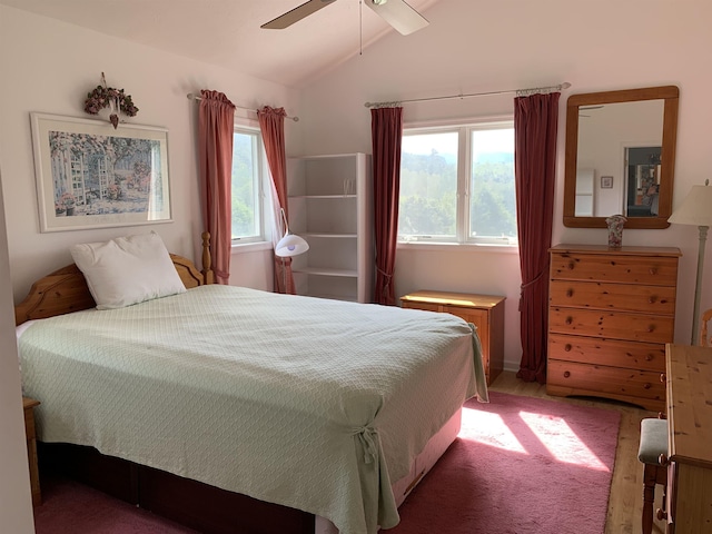 carpeted bedroom with ceiling fan and vaulted ceiling