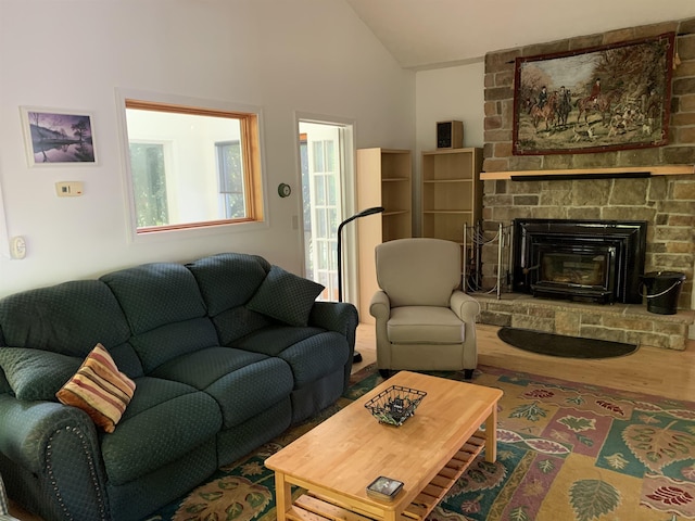 living room with lofted ceiling, a fireplace, and wood-type flooring