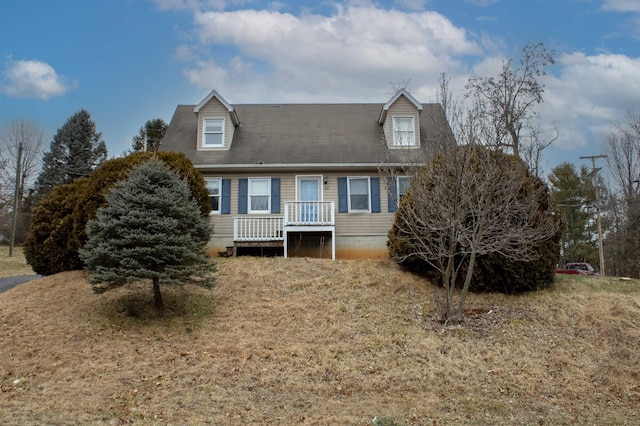 new england style home featuring a wooden deck and a front yard