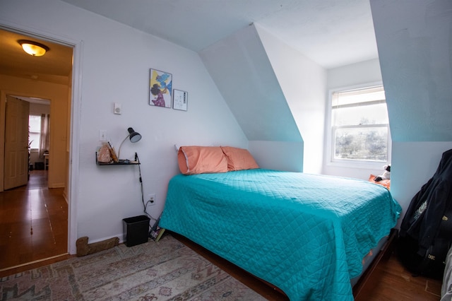 bedroom featuring lofted ceiling and dark hardwood / wood-style floors