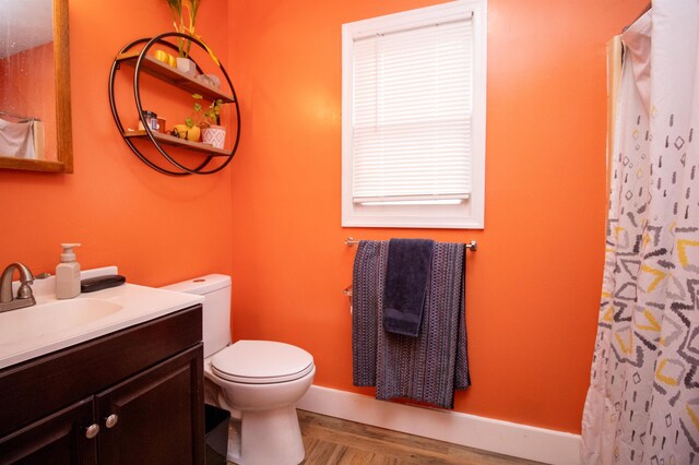 bathroom featuring vanity, hardwood / wood-style floors, curtained shower, and toilet