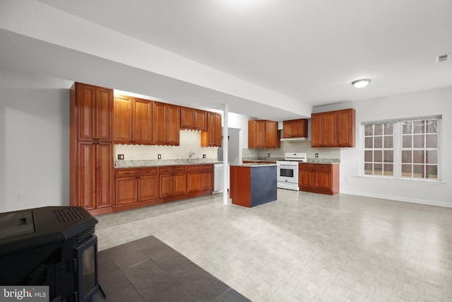 kitchen featuring light countertops, tasteful backsplash, open floor plan, and white appliances