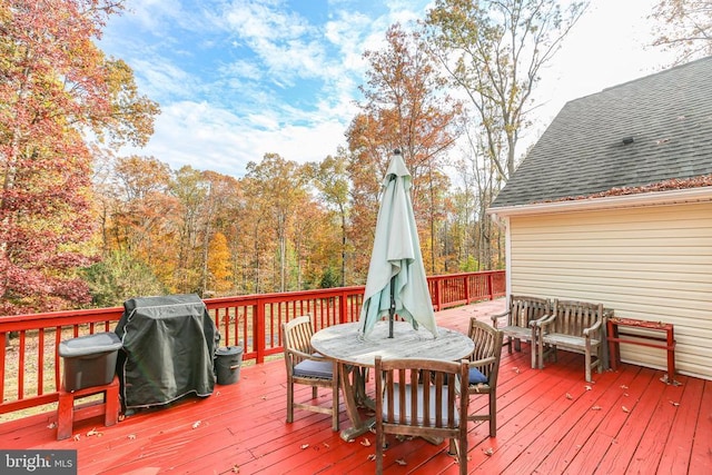 wooden terrace with outdoor dining space and grilling area