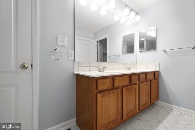 full bathroom featuring decorative backsplash, a sink, double vanity, baseboards, and tile patterned floors