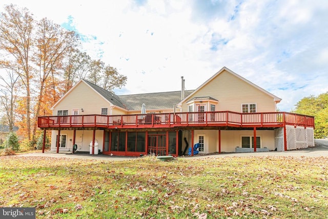 rear view of house with a lawn and a wooden deck