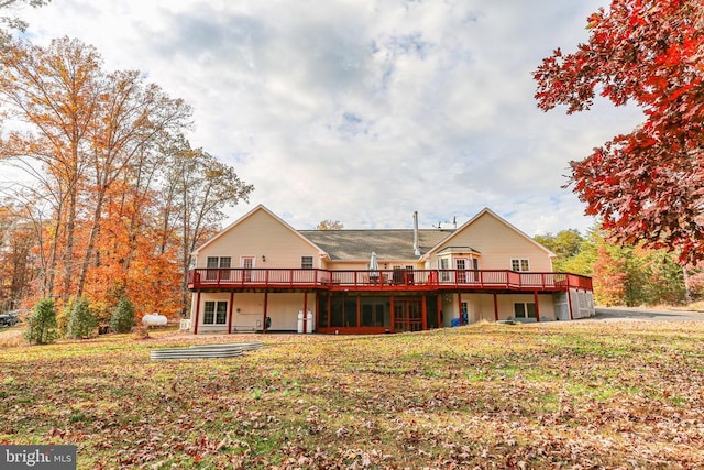 rear view of house with a yard and a wooden deck
