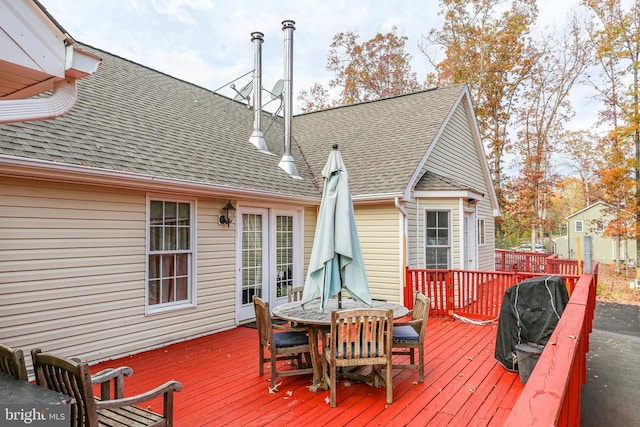 wooden deck with outdoor dining area and a grill