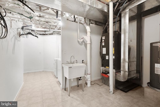 unfinished basement with water heater, independent washer and dryer, and baseboards
