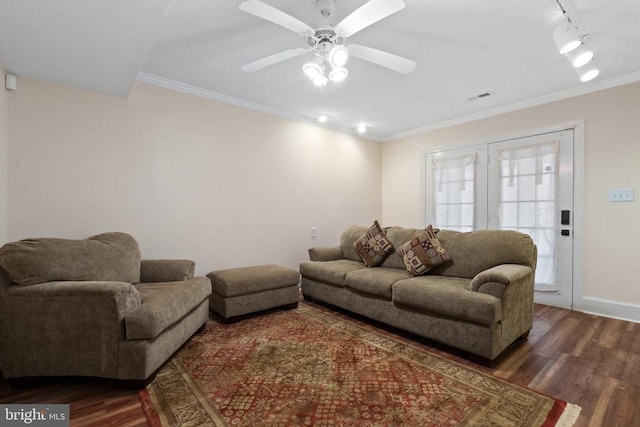 living area featuring baseboards, dark wood-style floors, visible vents, and ornamental molding