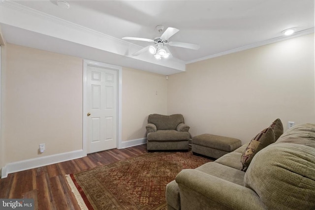 living area with crown molding, wood finished floors, baseboards, and ceiling fan