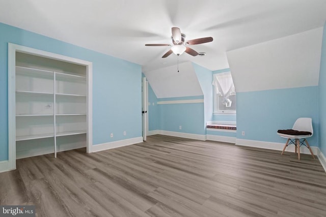 bonus room with a ceiling fan, vaulted ceiling, wood finished floors, and baseboards