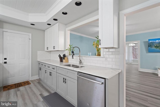 kitchen with a sink, backsplash, crown molding, and stainless steel dishwasher