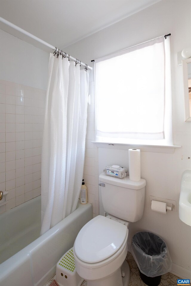 bathroom featuring shower / bath combo and toilet