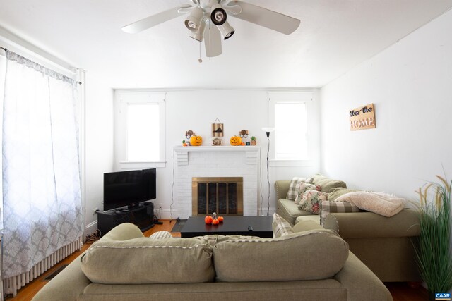 living room with hardwood / wood-style flooring, ceiling fan, and a fireplace