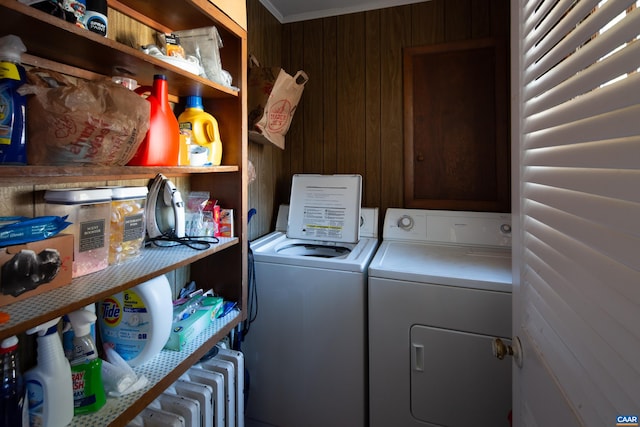 clothes washing area featuring washer and dryer and wood walls