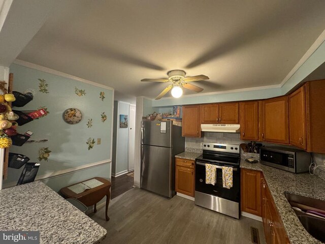 kitchen with dark wood-type flooring, ceiling fan, stainless steel appliances, light stone countertops, and decorative backsplash