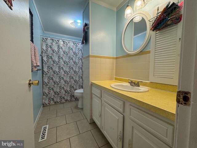 bathroom with tile walls, tile patterned flooring, vanity, toilet, and crown molding