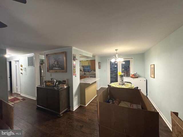 kitchen with stainless steel fridge, dark hardwood / wood-style flooring, decorative light fixtures, and a notable chandelier