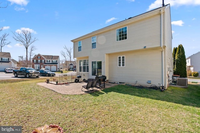 back of property featuring central air condition unit, a lawn, and a patio