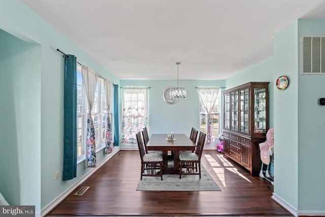 dining space with an inviting chandelier, plenty of natural light, visible vents, and dark wood-style flooring