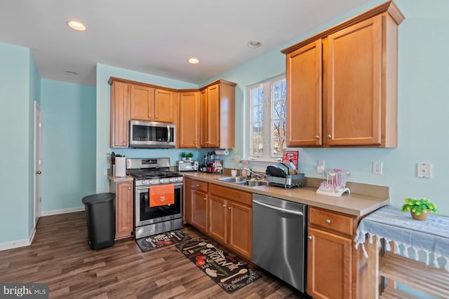 kitchen with recessed lighting, dark wood-style flooring, a sink, light countertops, and appliances with stainless steel finishes