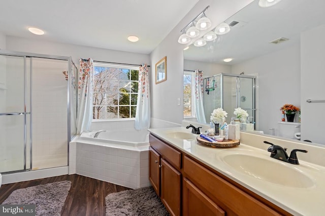 full bath with a garden tub, wood finished floors, a sink, and toilet