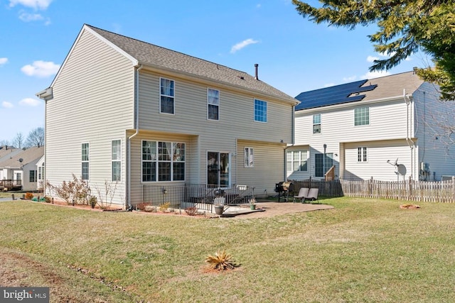 rear view of property with fence, a lawn, and a patio