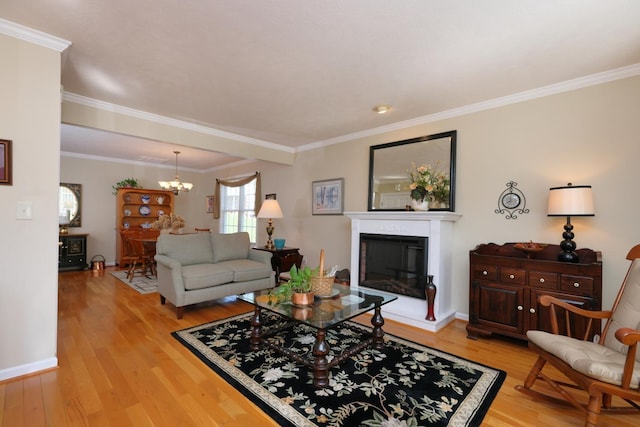 living room featuring crown molding, a chandelier, and light wood-type flooring