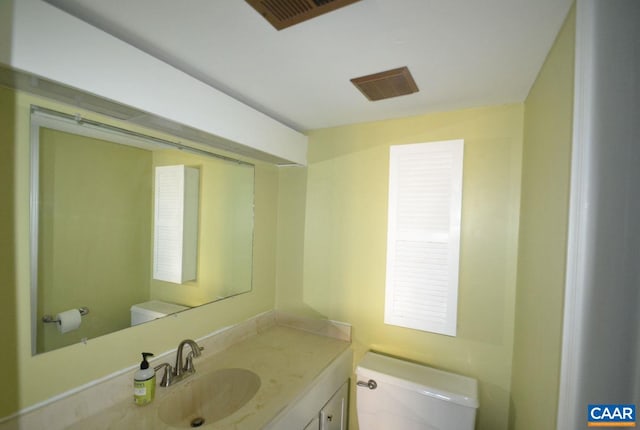 bathroom with toilet, visible vents, and vanity