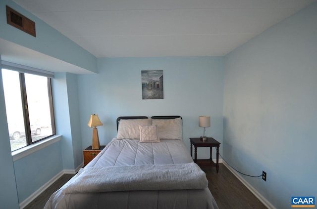 bedroom featuring dark wood-style flooring, visible vents, and baseboards